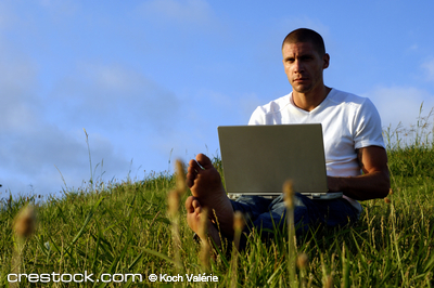 young man working with his computer in a field